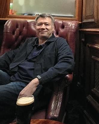 Eliphas Favre, seated in a panelled bar